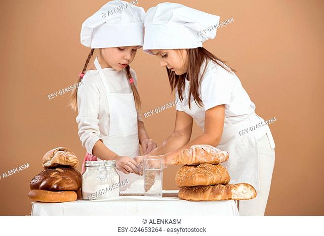5 years old girls cooking together, studio shot