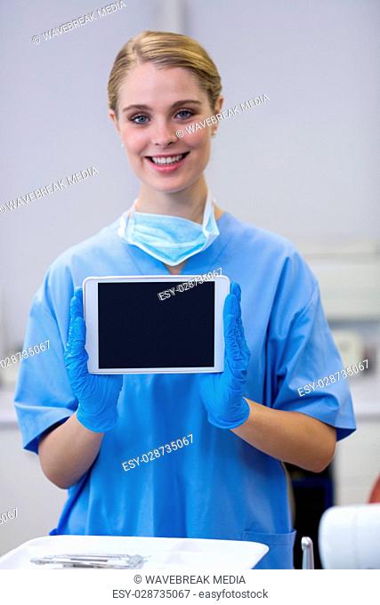 Portrait of smiling nurse holding digital tablet