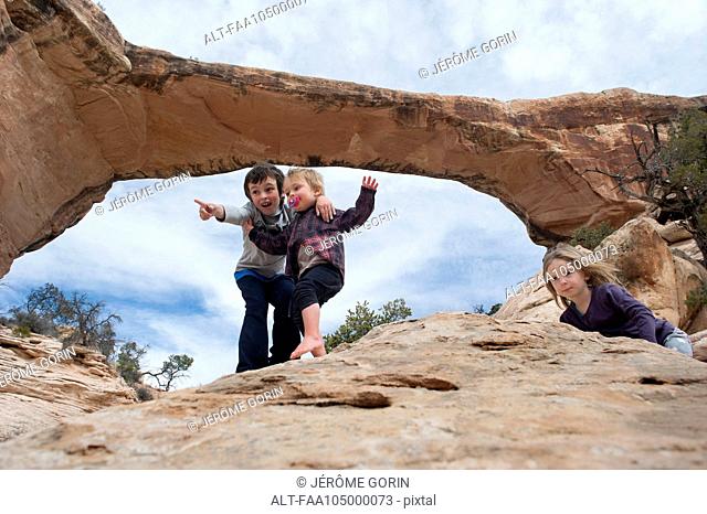 Children exploring near Owachomo Bridge, Natural Bridges National Monument, Utah, USA