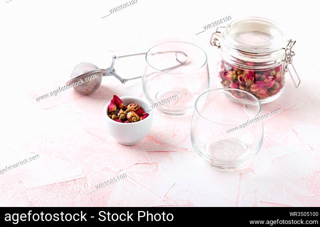 Herbal tea with dryed roses n glass jar and two glasses