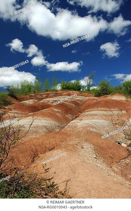 Red Badlands erosion and blue sky with clouds