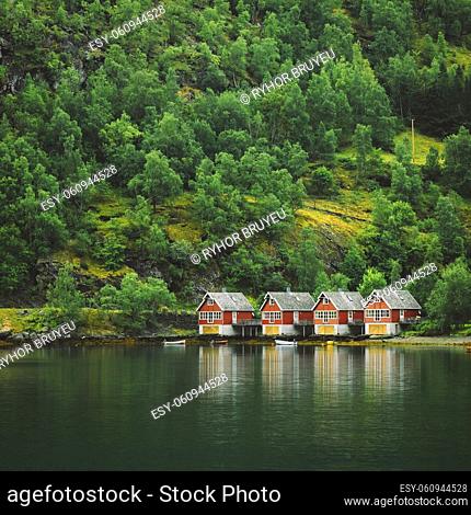 Red wooden docks in small tourist town of Flam on western side of Norway deep in fjords. Forest Background