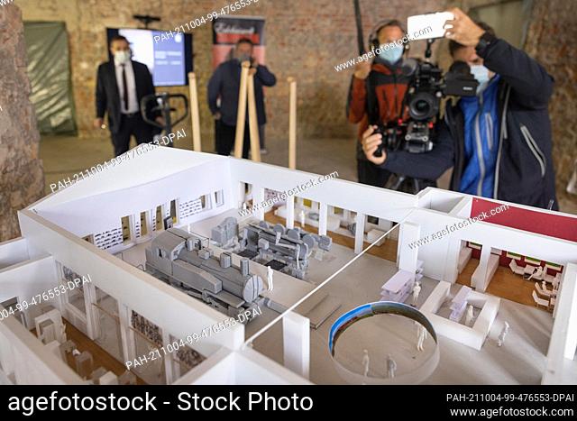 04 October 2021, Thuringia, Meiningen: People look at the model for the construction of the ""Steam Locomotive World Meiningen"" on the sidelines of the laying...