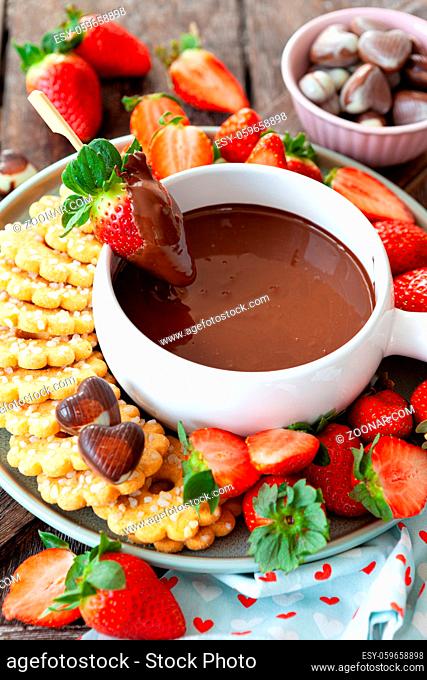Schokoladen Fondue mit frischen Erdbeeren und Keksen