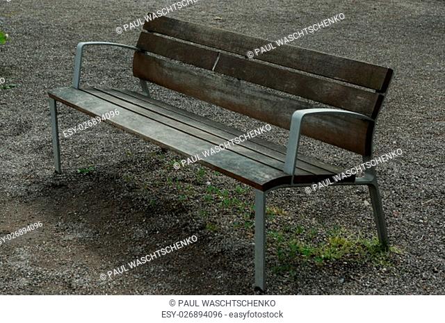 a brown lonely wooden bench in the park