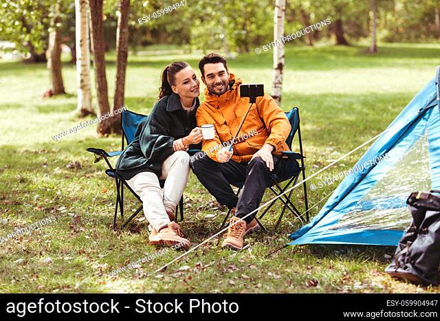 couple drinking tea and taking selfie at tent camp