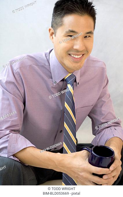 Asian businessman holding coffee mug