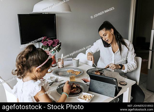 Woman talking via phone during meal