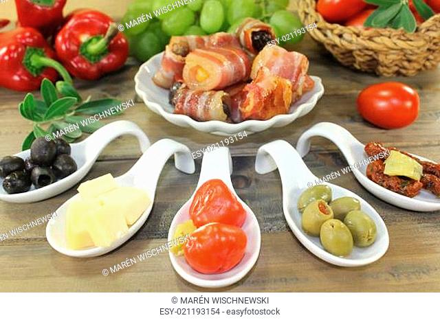stuffed tapas with plums, figs, apricots and bacon on wooden background