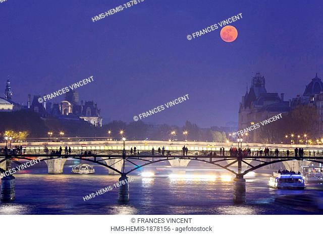 France, Paris, area listed as World Heritage by UNESCO, the Passerelle des Arts and river boats under the full moon