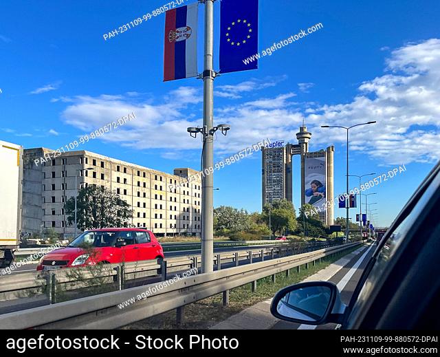 06 November 2023, Serbia, Belgrad: The Serbian and EU flags hang from the lampposts in the Serbian capital, with the Genex Tower in the background