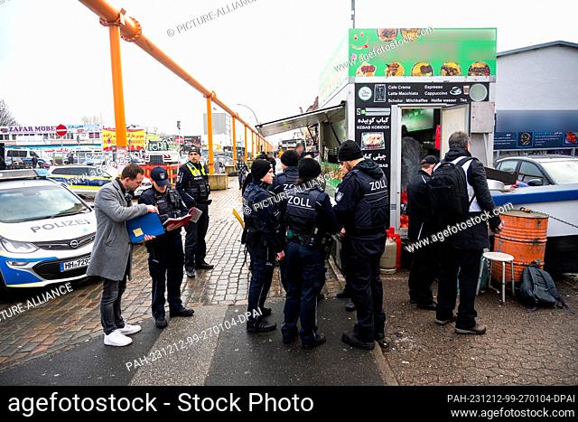 12 December 2023, Hamburg: Police, customs officers and authorities stand in front of a snack bar in the Rothenburgsort district of Billstraße