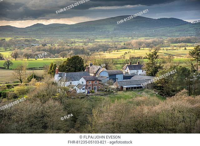 View of farmhouse, barns and farmland, Lydbury North, Shropshire, England, April