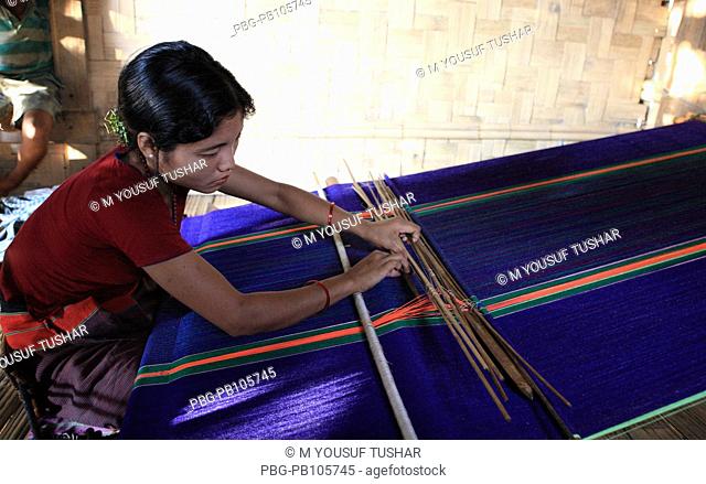 A Marma tribal woman weaving cloth on traditional handloom Bandarban, Bangladesh December 2009
