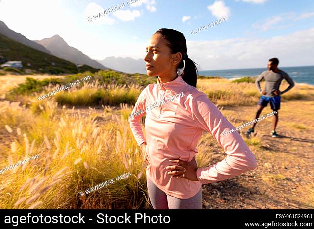 Fit african american couple in sportswear standing in tall grass