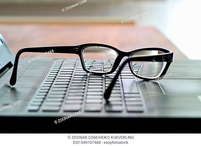 Brille auf der Computer-Tastatur während einer Pause