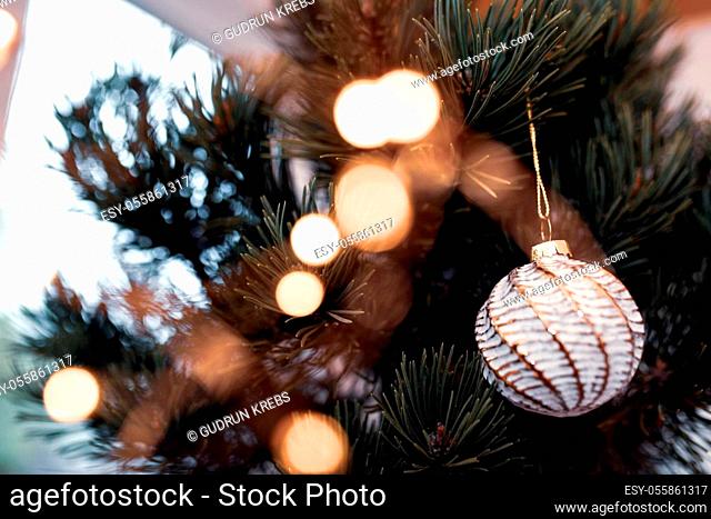 Christmas tree decoration with balls and golden bokeh. Close-up with short depth of field. Atmospheric background for a christmas concept