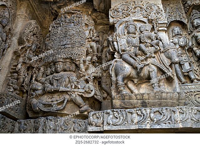 Sculptures on the west side walls. Ravana lifting Kailasa on the left and Shiva-Parvati on Nadi on the right. Hoysaleshwara temple, Halebidu, Karnataka, india