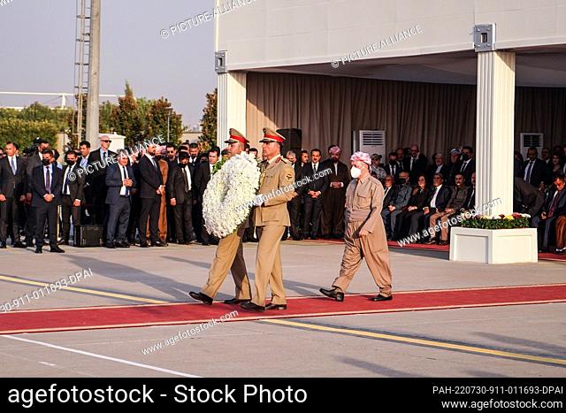 30 July 2022, Iraq, Erbil city: Leader of the Kurdistan Democratic Party (PDK) Masoud Barzani lays a wreath during a ceremony to receive the remains of 100...