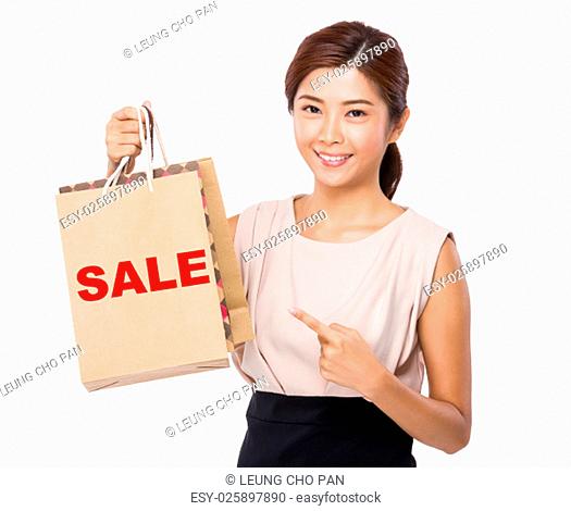 Asian woman finger point to shopping bag and showing a word sale