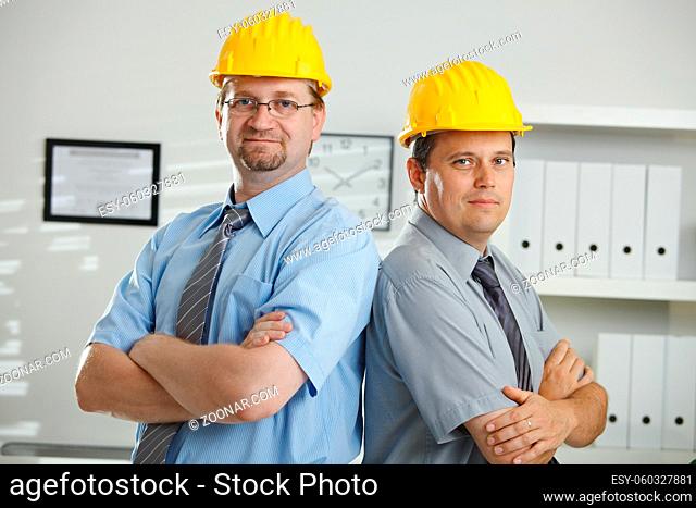 Engineers in hardhats posing for teamphoto at office