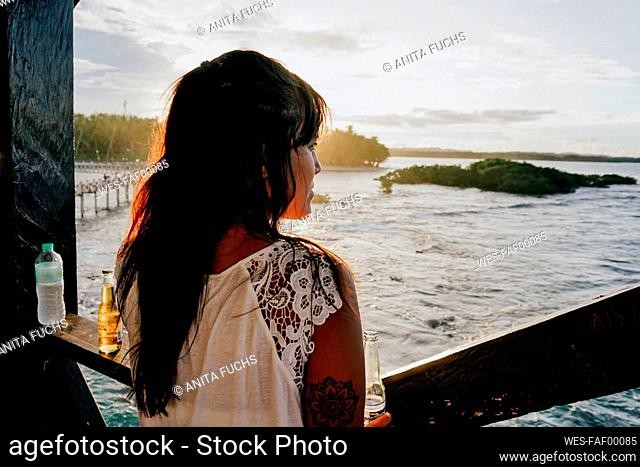 Woman watching the sunset on Siargao Island, Philippines