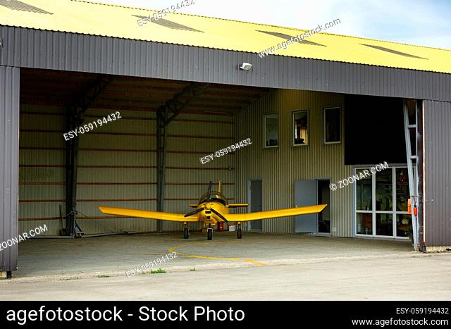 small airplane standing in big hangar. copyspace