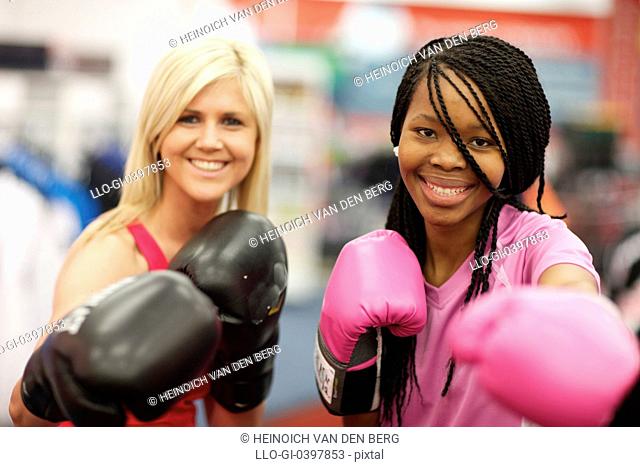 Two young women wearing boxing gloves and looking at the camera, Pietermaritzburg, KwaZulu-Natal, South Africa