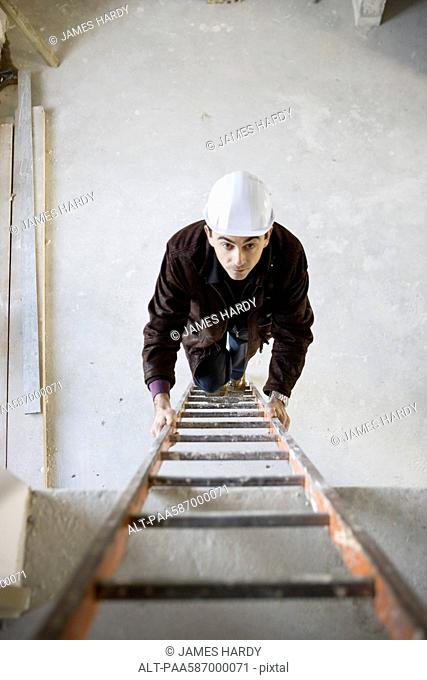 Construction worker climbing ladder