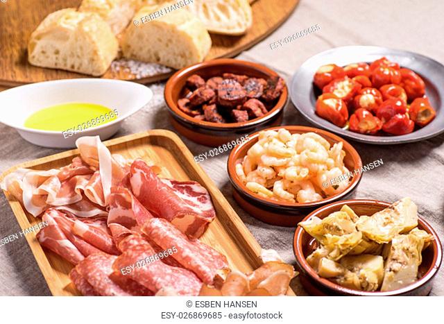Tapas food, served in small bowls cold meat, goat cheese. A meal for sharing