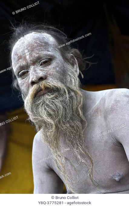 Naga baba the body coated with the ashes of the sacred fire for a purification on the ghats in benares, awaiting the shivaratri. UP, india