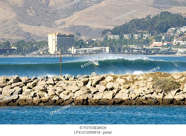 A Surfer takes on a huge wave during a big swell Marina Park Ventura California USA