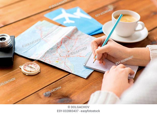 vacation, tourism, travel, destination and people concept - close up of traveler hands with blank notepad and pencil