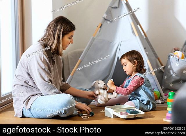 mother and daughter playing doctor at home