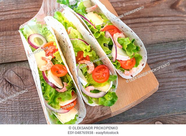 Tacos with shrimps, brie and fresh vegetables