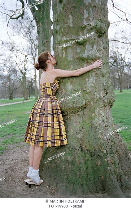 A woman hugging a tree