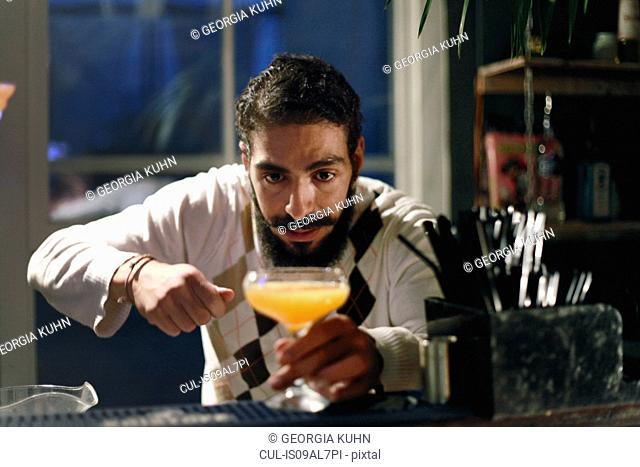 Bartender serving cocktail at bar