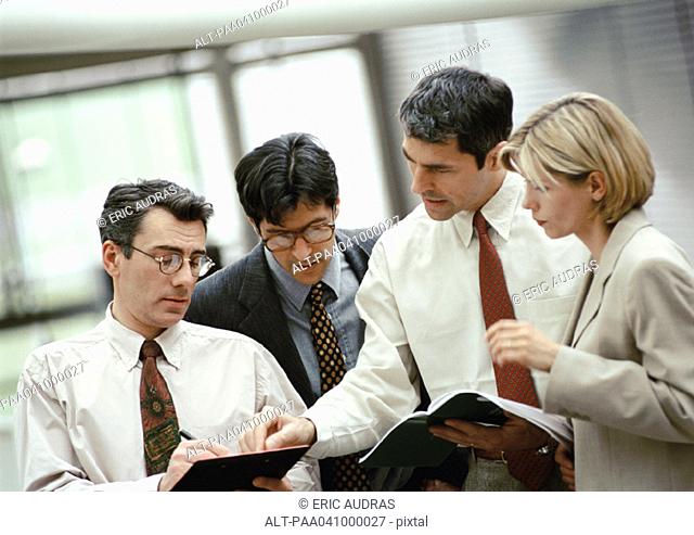 Four business people examining document