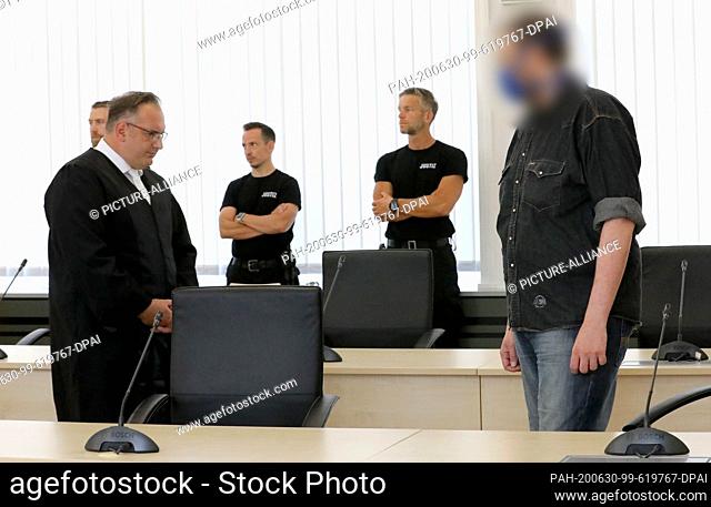 30 June 2020, Mecklenburg-Western Pomerania, Rostock: Defense attorney Jens Otte (l), attorney at law, waits with the defendant in the trial for the double...