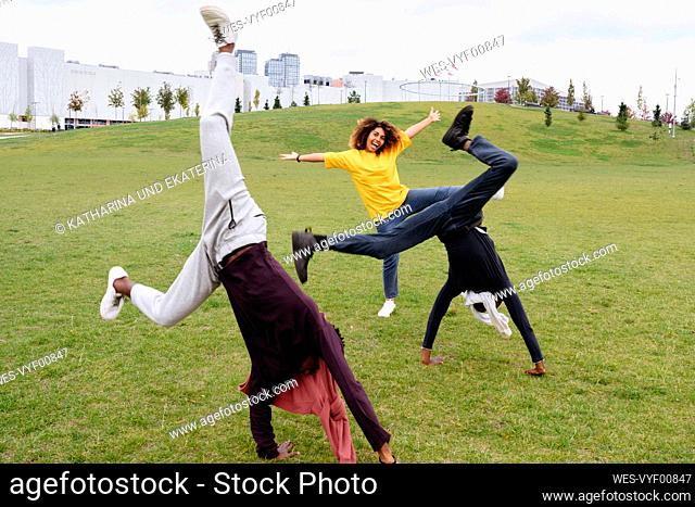 Carefree young men doing cartwheel by friend in park