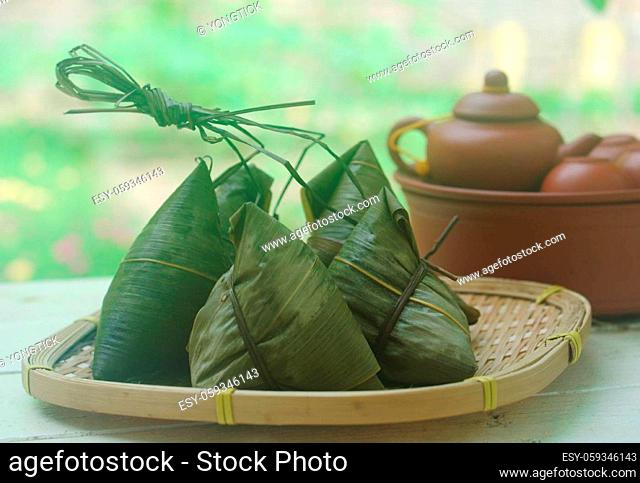 Chinese tradition food - Chinese Steamed Rice Dumpling with green background outdoor.Zongzi or traditional chinese sticky rice dumpling usually taken during...