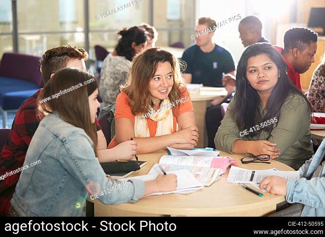 College students studying and talking at library table