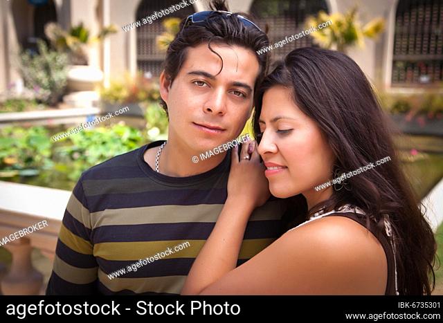 Attractive hispanic couple portrait enjoying each other outdoors