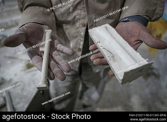 09 February 2021, Syria, Al Bab: A picture made available on 11 February 2021 shows Ali Alsaleh, 58, holding a mild of a scale pillar at his workshop