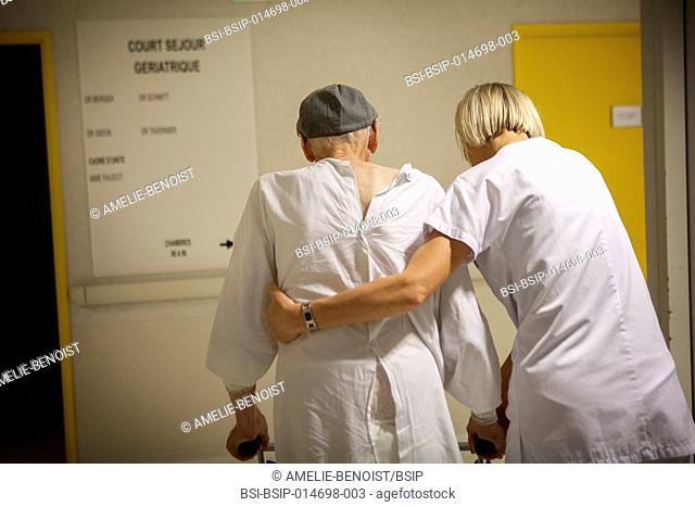 Reportage with a team of physiotherapists in a hospital in Haute-Savoie in France. A physiotherapist helps a geriatric patient to practice walking
