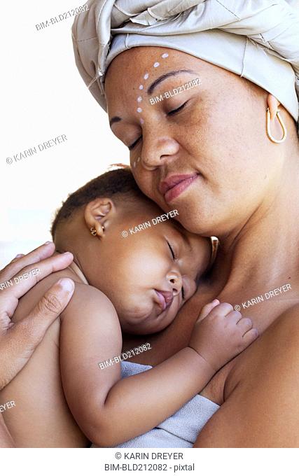 Mixed race mother cradling baby