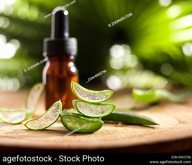 Aloe vera essential oil on tropical leaves background