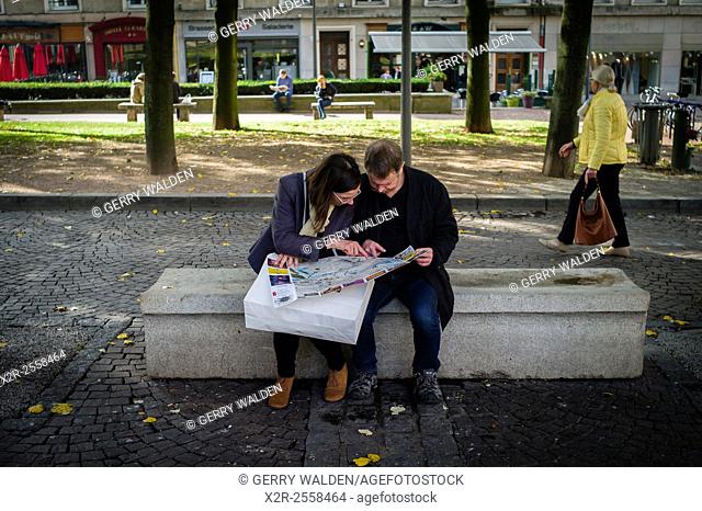 Two people sit and study a map in the precepts of Rouen Cathedral, Normandy, France