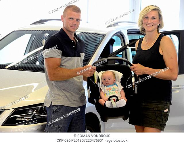 Czech athlete Barbora Spotakova (right) and her partner Lukas with sun Janek poses in front of the car which she received on July 22, 2013 in Prague