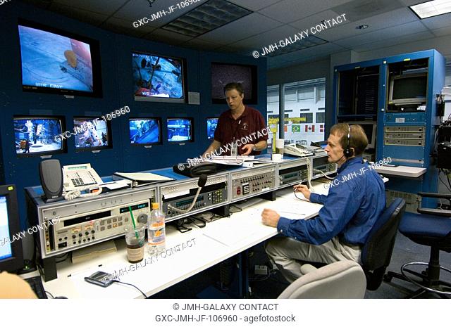 Astronaut Steven G. MacLean (seated), STS-115 mission specialist representing the Canadian Space Agency, observes training activities of his crewmates from the...